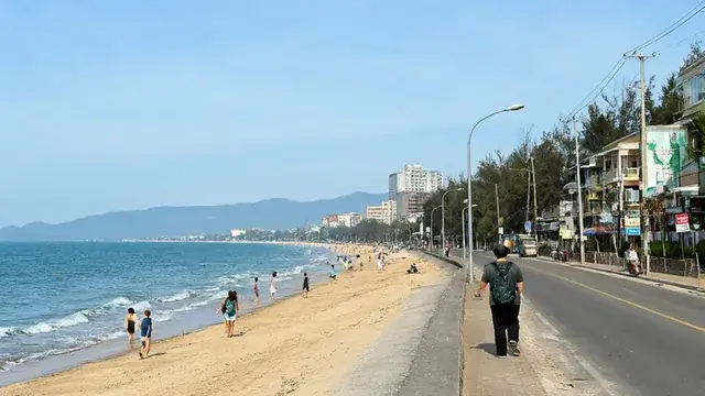 붕따우 뒷해변에서 바다를 바라보는 가족 여행